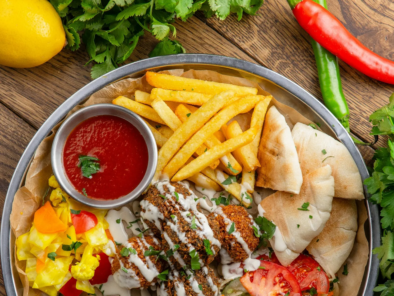 Chicken shawarma plate with vegetables, pita and garlic sauce