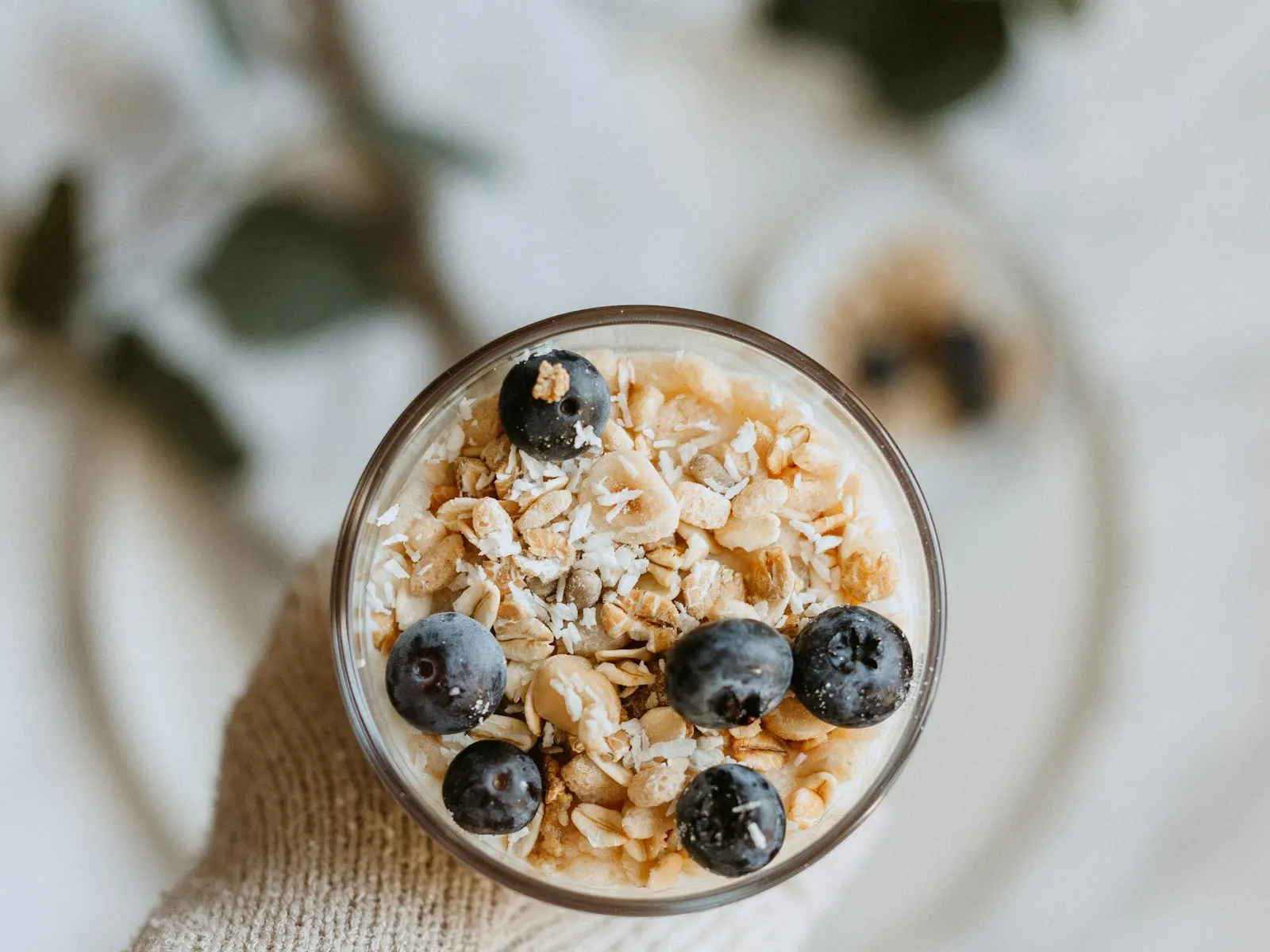 Glass of overnight oats topped with blueberries