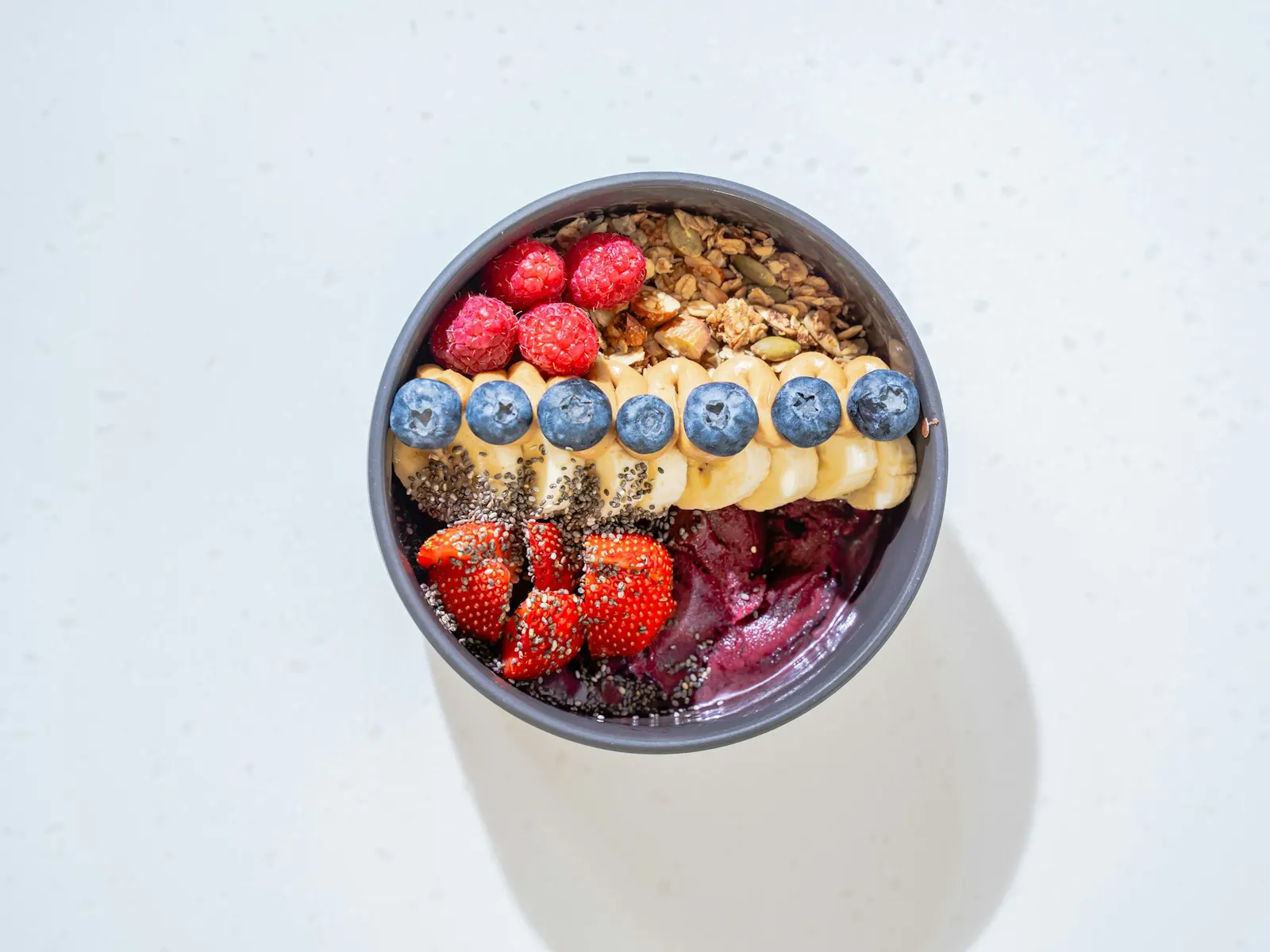 Protein yogurt bowl topped with berries, banana and granola